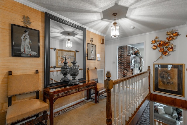 corridor featuring crown molding, an upstairs landing, carpet floors, and a textured ceiling