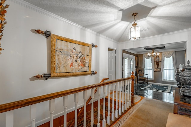 interior space featuring crown molding, a chandelier, an upstairs landing, and a textured ceiling