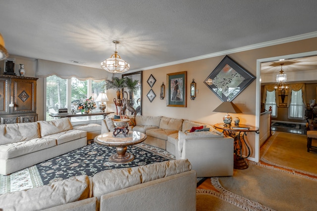 living room with ornamental molding, a textured ceiling, a notable chandelier, and carpet flooring