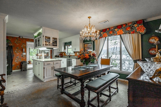 dining space featuring plenty of natural light, visible vents, wallpapered walls, and an inviting chandelier