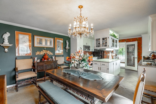 tiled dining area with sink, an inviting chandelier, crown molding, and a textured ceiling