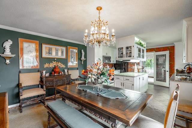 tiled dining area featuring a textured ceiling, crown molding, a sink, and a chandelier