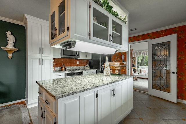 kitchen featuring crown molding, tasteful backsplash, light stone countertops, and white cabinets