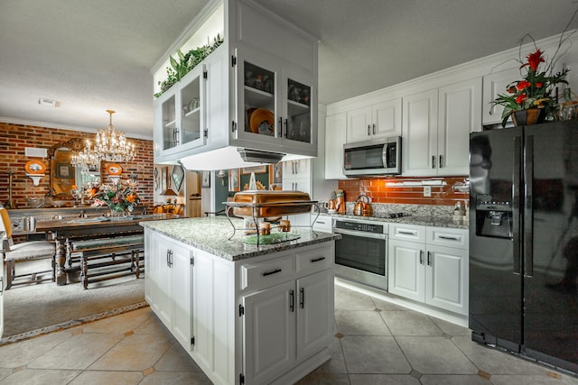 kitchen featuring black appliances, a center island, an inviting chandelier, and white cabinetry