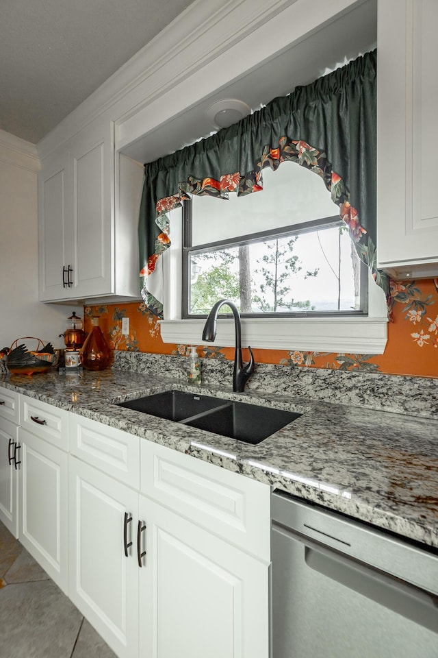 kitchen with crown molding, a sink, light stone countertops, dishwasher, and white cabinets