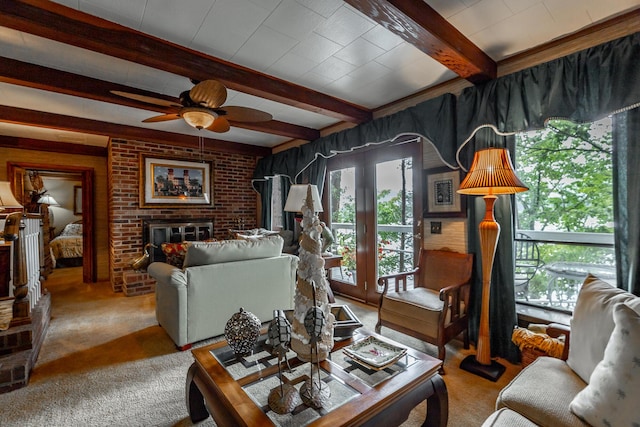 living room featuring carpet floors, beamed ceiling, ceiling fan, and a fireplace