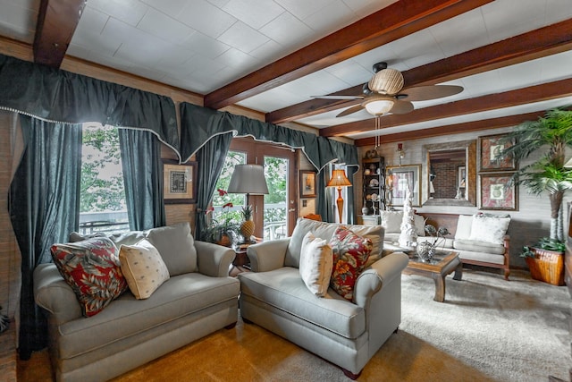 carpeted living area featuring beam ceiling and ceiling fan