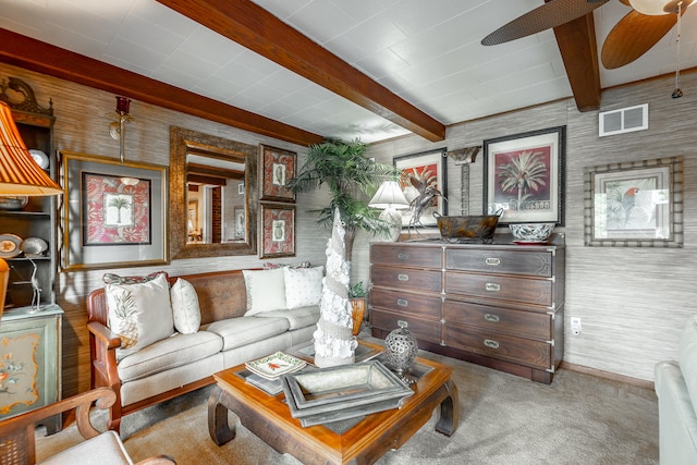 carpeted living room with ceiling fan and beam ceiling