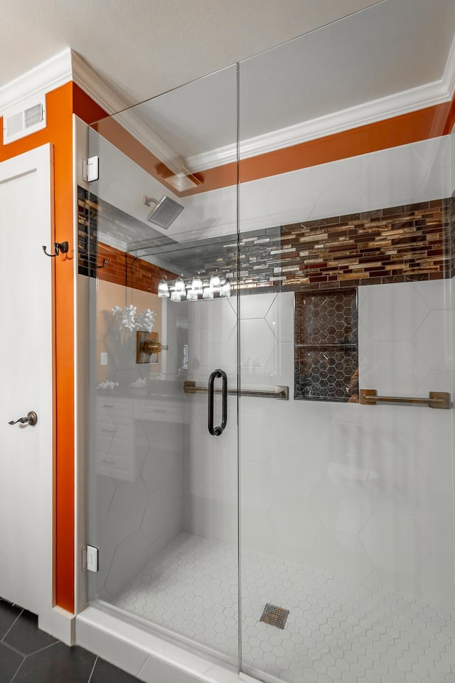 bathroom with a stall shower, visible vents, tile patterned flooring, and ornamental molding