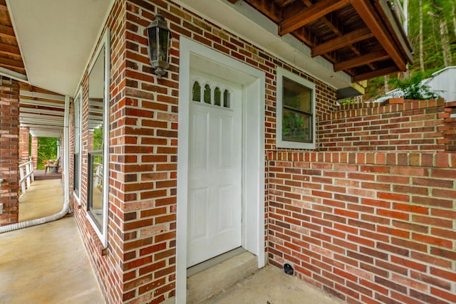 doorway to property with brick siding