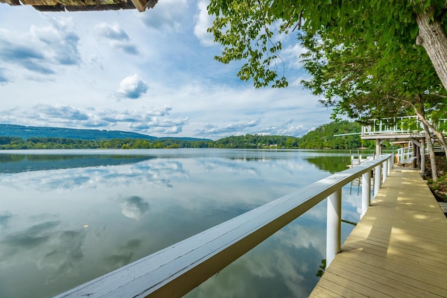 dock area featuring a forest view and a water view