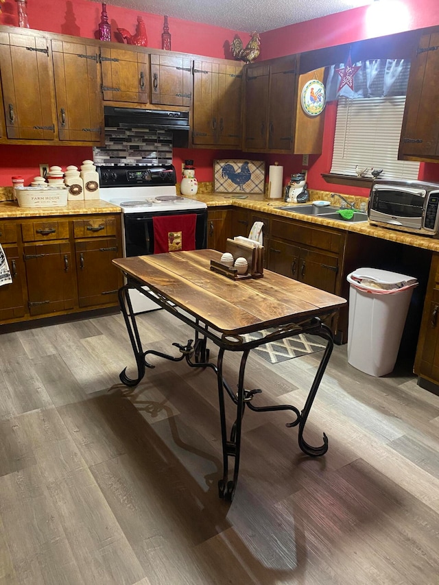 kitchen featuring a textured ceiling, exhaust hood, white range with electric cooktop, and light hardwood / wood-style floors