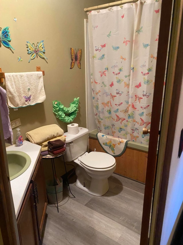 full bathroom featuring vanity, toilet, shower / tub combo with curtain, and hardwood / wood-style floors