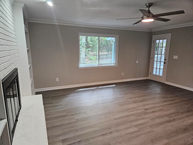 unfurnished living room with a textured ceiling, a brick fireplace, hardwood / wood-style floors, ceiling fan, and ornamental molding