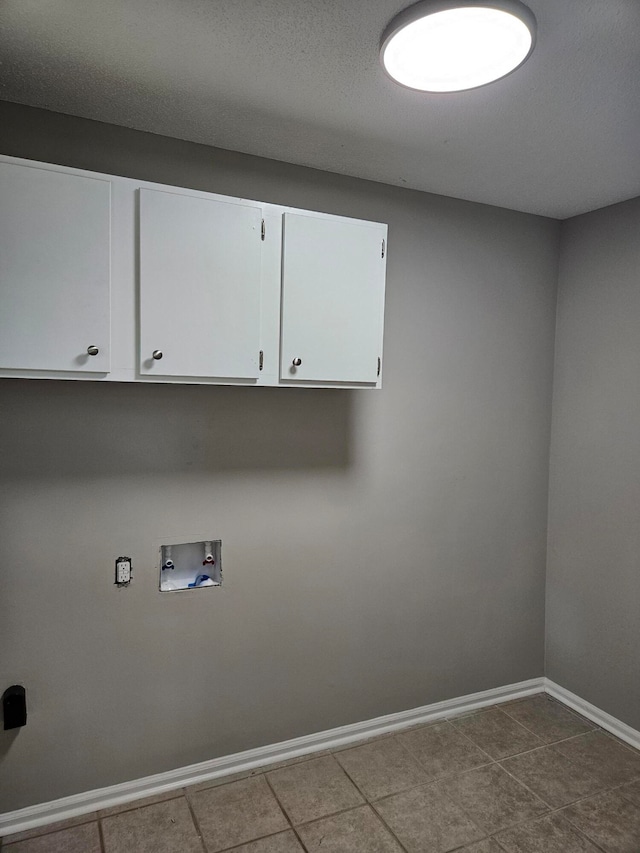 washroom with hookup for a washing machine, cabinets, tile patterned floors, and a textured ceiling