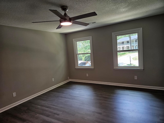 spare room with dark hardwood / wood-style flooring, plenty of natural light, ceiling fan, and a textured ceiling