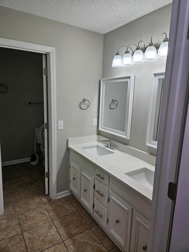 bathroom featuring tile patterned flooring, toilet, a textured ceiling, and vanity