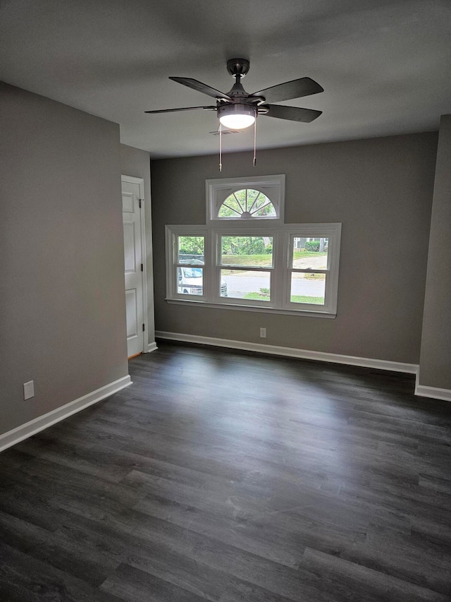 empty room with ceiling fan and dark hardwood / wood-style floors