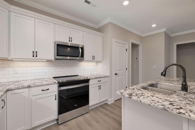 kitchen featuring stainless steel appliances, light stone countertops, sink, and white cabinets