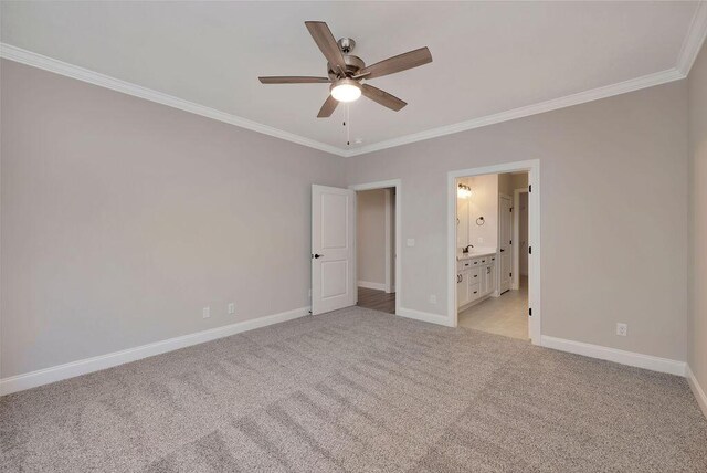 unfurnished bedroom with ensuite bath, ornamental molding, light colored carpet, and ceiling fan