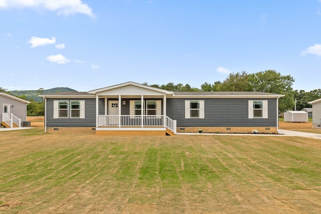 view of front of property featuring covered porch, a front lawn, and a storage unit