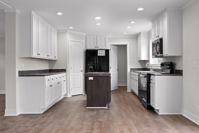 kitchen with a kitchen island, dark wood-type flooring, ornamental molding, black appliances, and white cabinetry