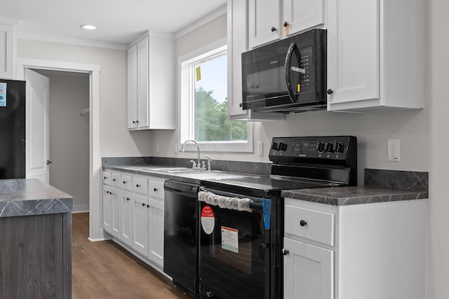 kitchen with dark wood-type flooring, white cabinets, black appliances, and sink