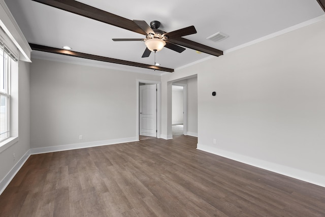 empty room featuring ceiling fan, a wealth of natural light, wood-type flooring, and beam ceiling