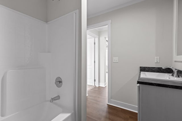 bathroom with washtub / shower combination, hardwood / wood-style flooring, and vanity