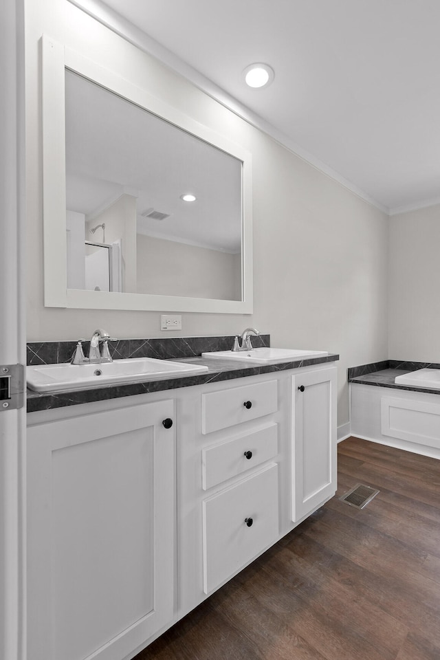 bathroom featuring hardwood / wood-style floors, crown molding, and vanity