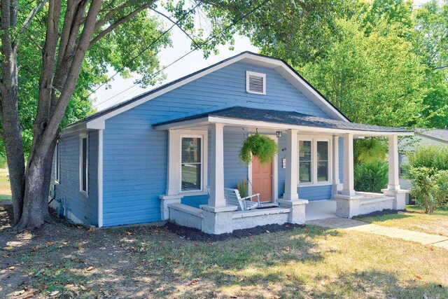 back of house featuring a yard and a porch