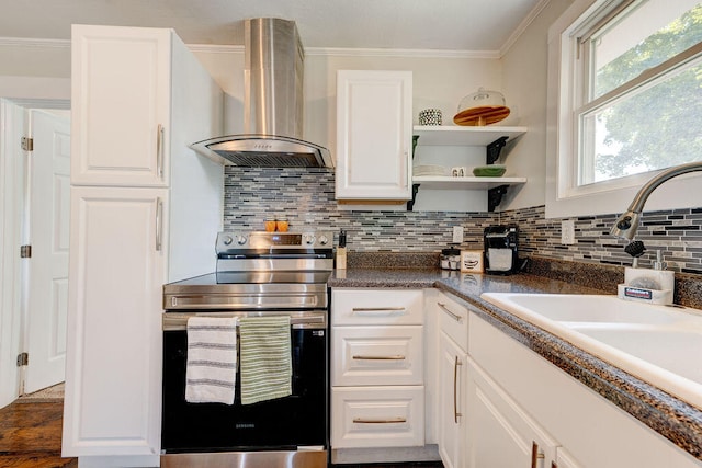 kitchen featuring electric stove, sink, decorative backsplash, white cabinets, and wall chimney range hood