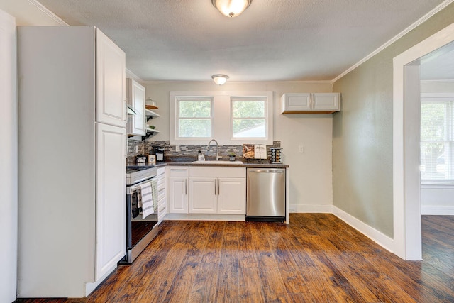 kitchen with dark hardwood / wood-style flooring, backsplash, stainless steel appliances, sink, and white cabinetry