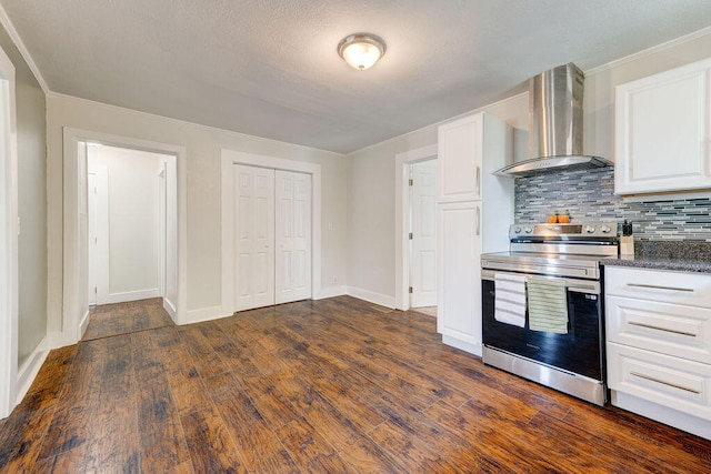 kitchen featuring dark wood-type flooring, stainless steel electric stove, white cabinets, and wall chimney range hood