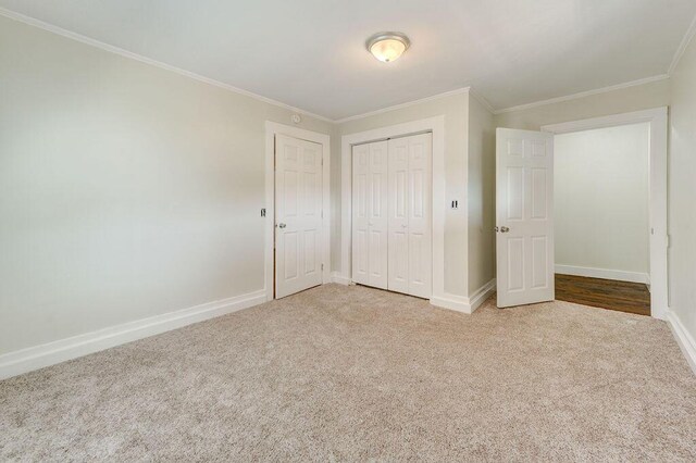 unfurnished bedroom with ornamental molding, light carpet, and a closet