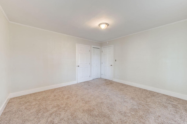 empty room with crown molding and carpet