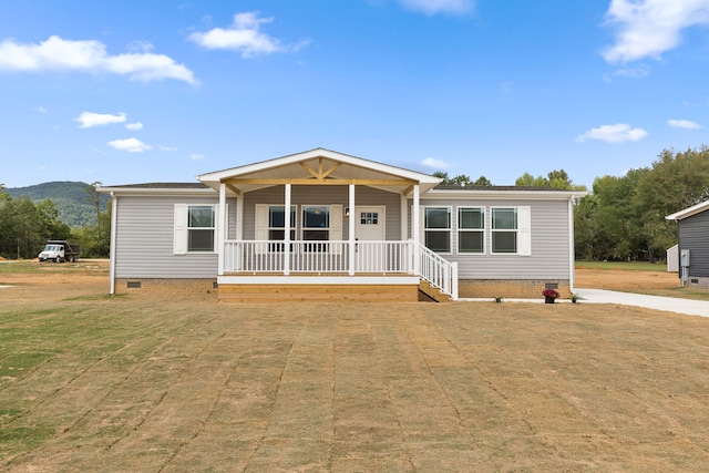 manufactured / mobile home featuring a front yard and covered porch