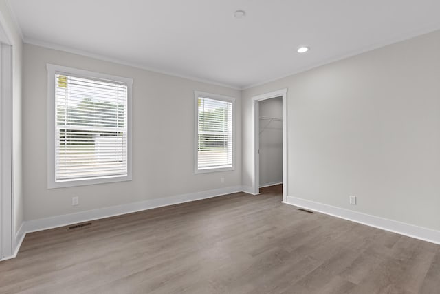 unfurnished room featuring ornamental molding, plenty of natural light, and light hardwood / wood-style floors