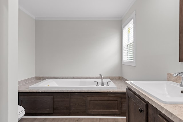 bathroom with ornamental molding, a tub, vanity, and toilet