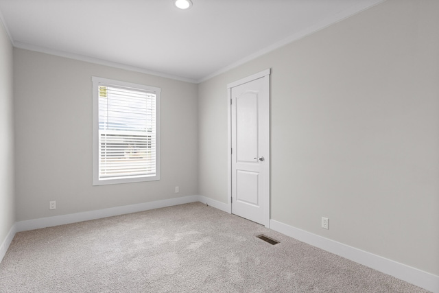 carpeted empty room featuring crown molding