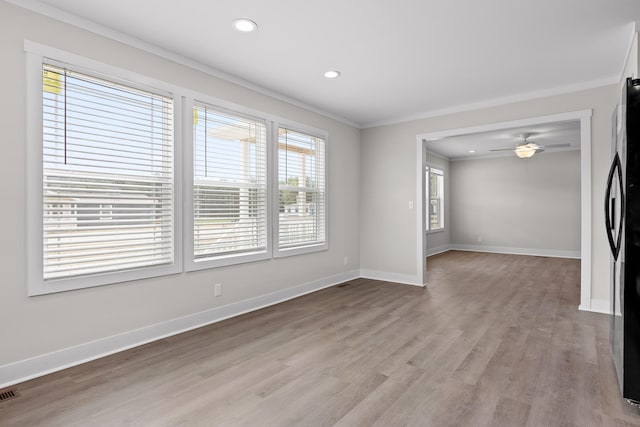 unfurnished room with ornamental molding, ceiling fan, a wealth of natural light, and light hardwood / wood-style flooring