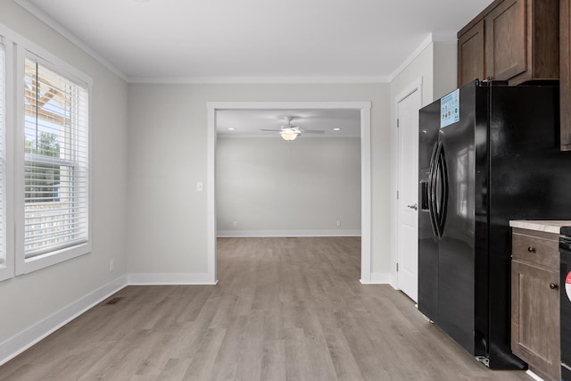 kitchen featuring light hardwood / wood-style floors, black fridge, ornamental molding, and ceiling fan