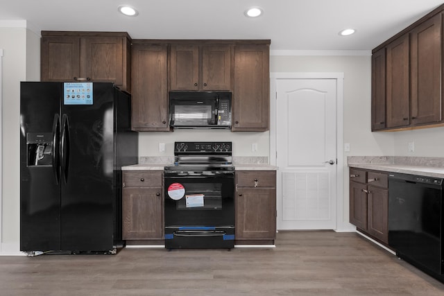 kitchen featuring black appliances, dark brown cabinetry, crown molding, and light hardwood / wood-style flooring