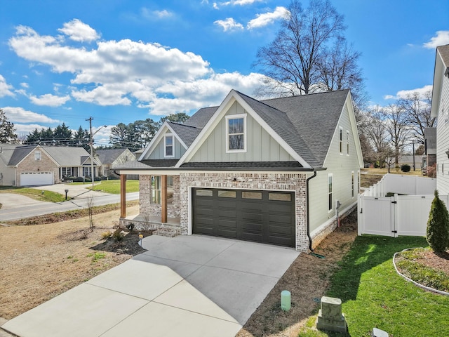 view of front facade with board and batten siding, a shingled roof, a porch, driveway, and a gate