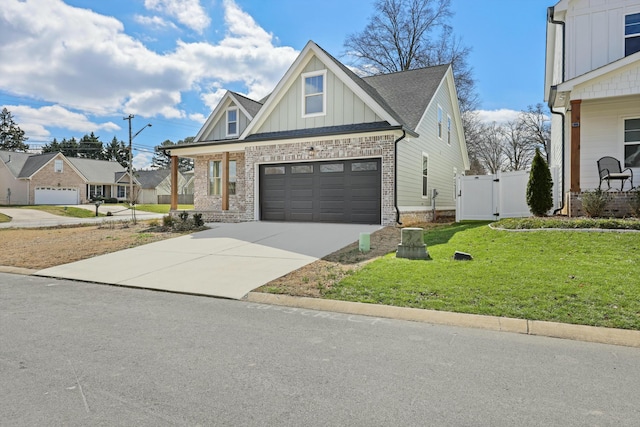 craftsman-style house with a front yard, a gate, concrete driveway, board and batten siding, and brick siding