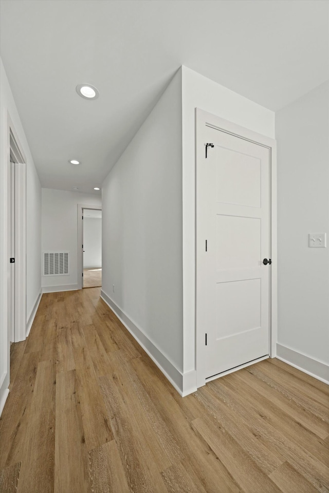 hall with recessed lighting, visible vents, light wood-style flooring, and baseboards