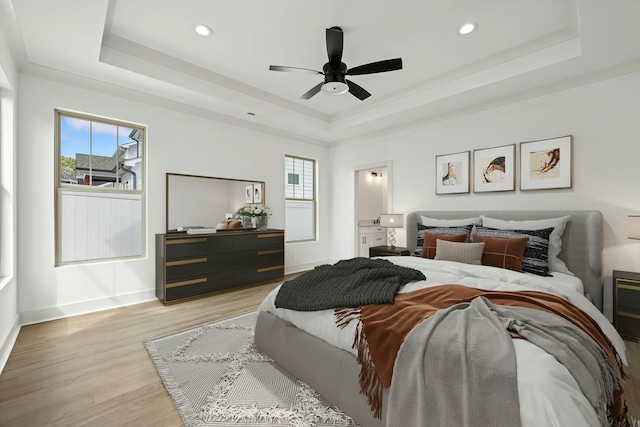 bedroom featuring a tray ceiling and multiple windows