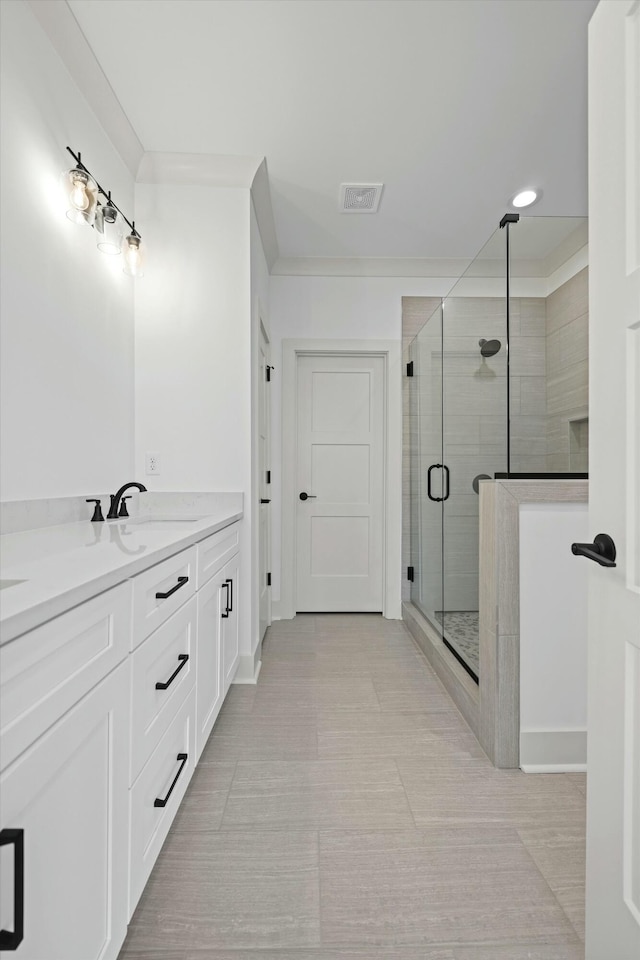 bathroom featuring tile patterned floors, visible vents, a shower stall, baseboards, and vanity