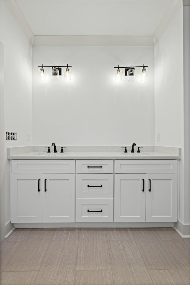 full bathroom with double vanity, ornamental molding, and a sink