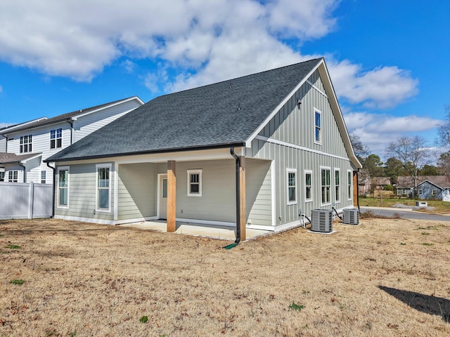 rear view of property with central air condition unit, a patio, and roof with shingles